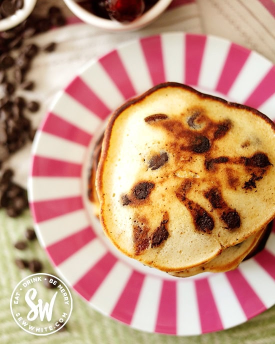 Close up beautiful golden brown Chocolate Cherry Pancakes on a pink stripy plate.