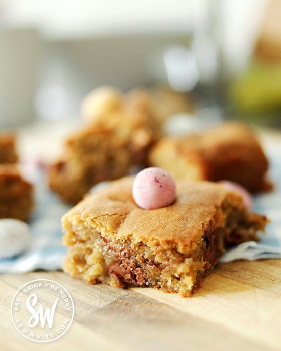 Mini Egg Cookie Traybake slice with soft middle and chopped up mini eggs inside.