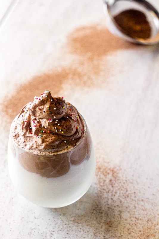 whipped chocolate with sprinkles and chocolate powder on a marble board