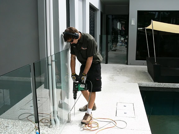 Drilling holes for termite barrier.