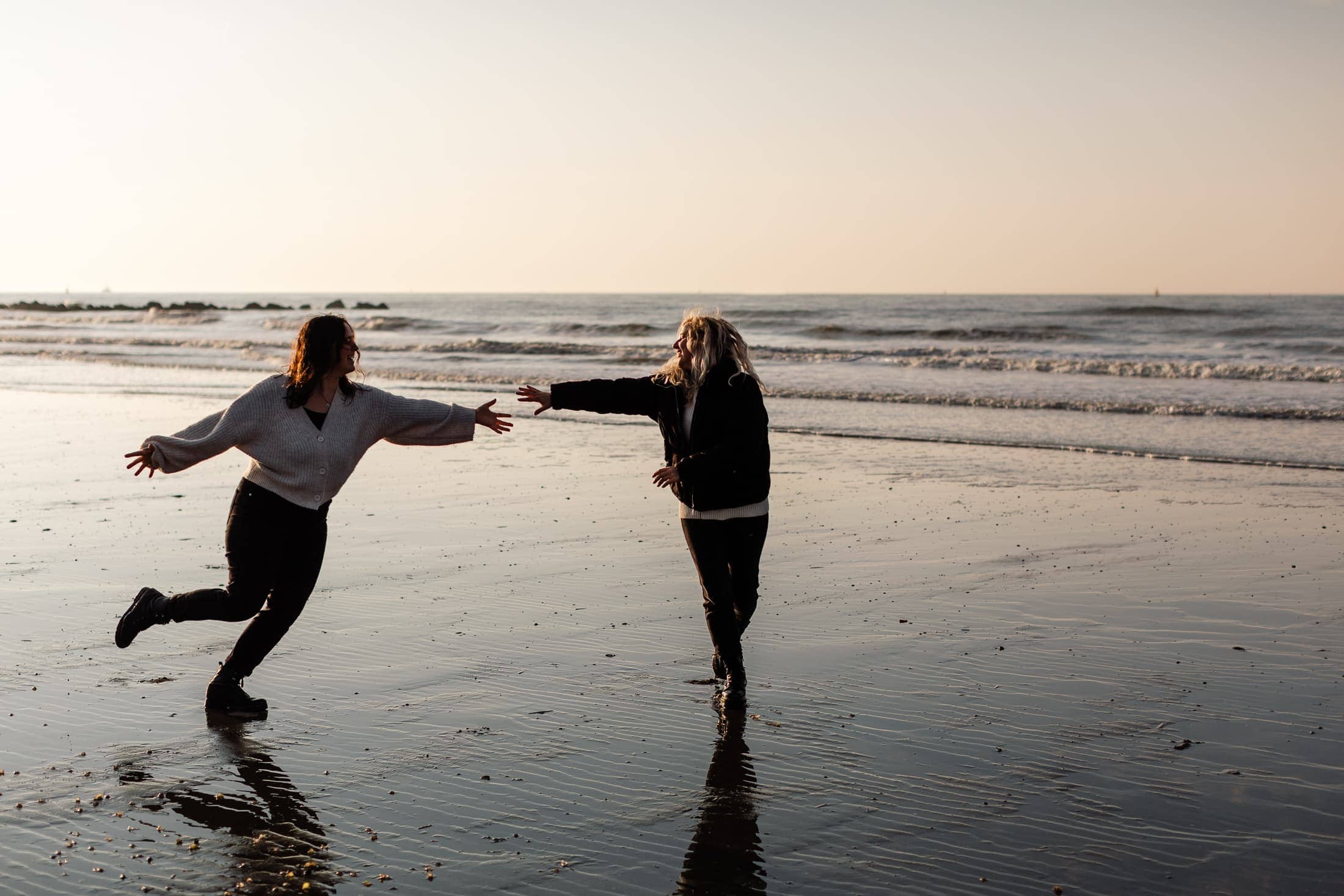 Tine en Karlijne dansen op het strand van Oostende bij golden hour fotograaf