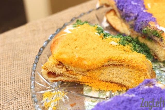 a slice of king cake with yellow colored sugar on top