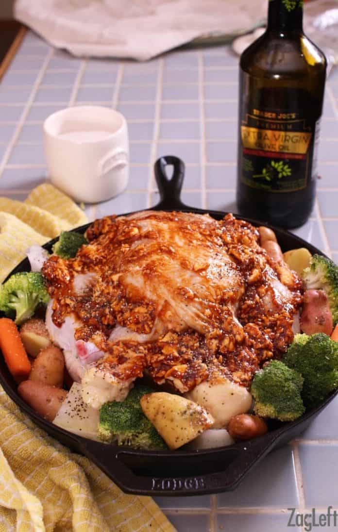 butter and barbecue sauce on top of a whole chicken in a skillet surrounded by vegetables | zagleft