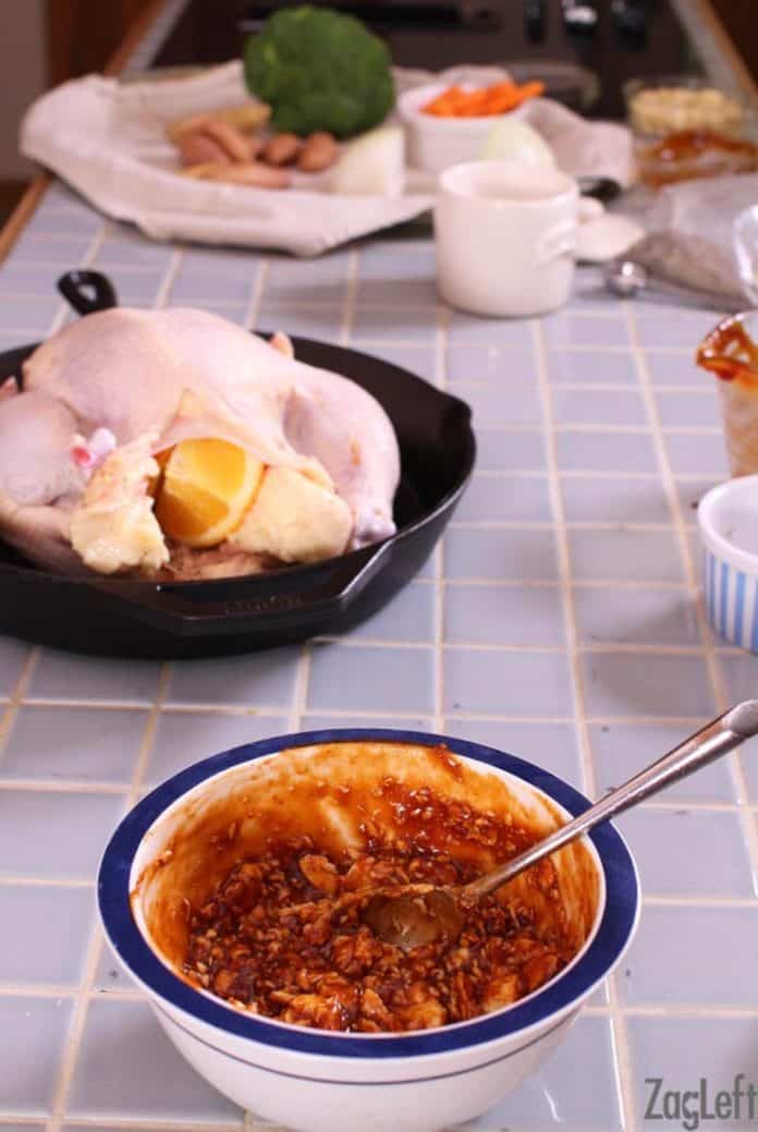 mixing bbq and butter together to add to the top of a whole roasting chicken which is sitting in a skillet | zagleft