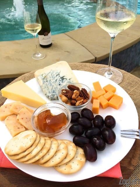 Cheese Plate shown next to pool with glass of wine - ZagLeft