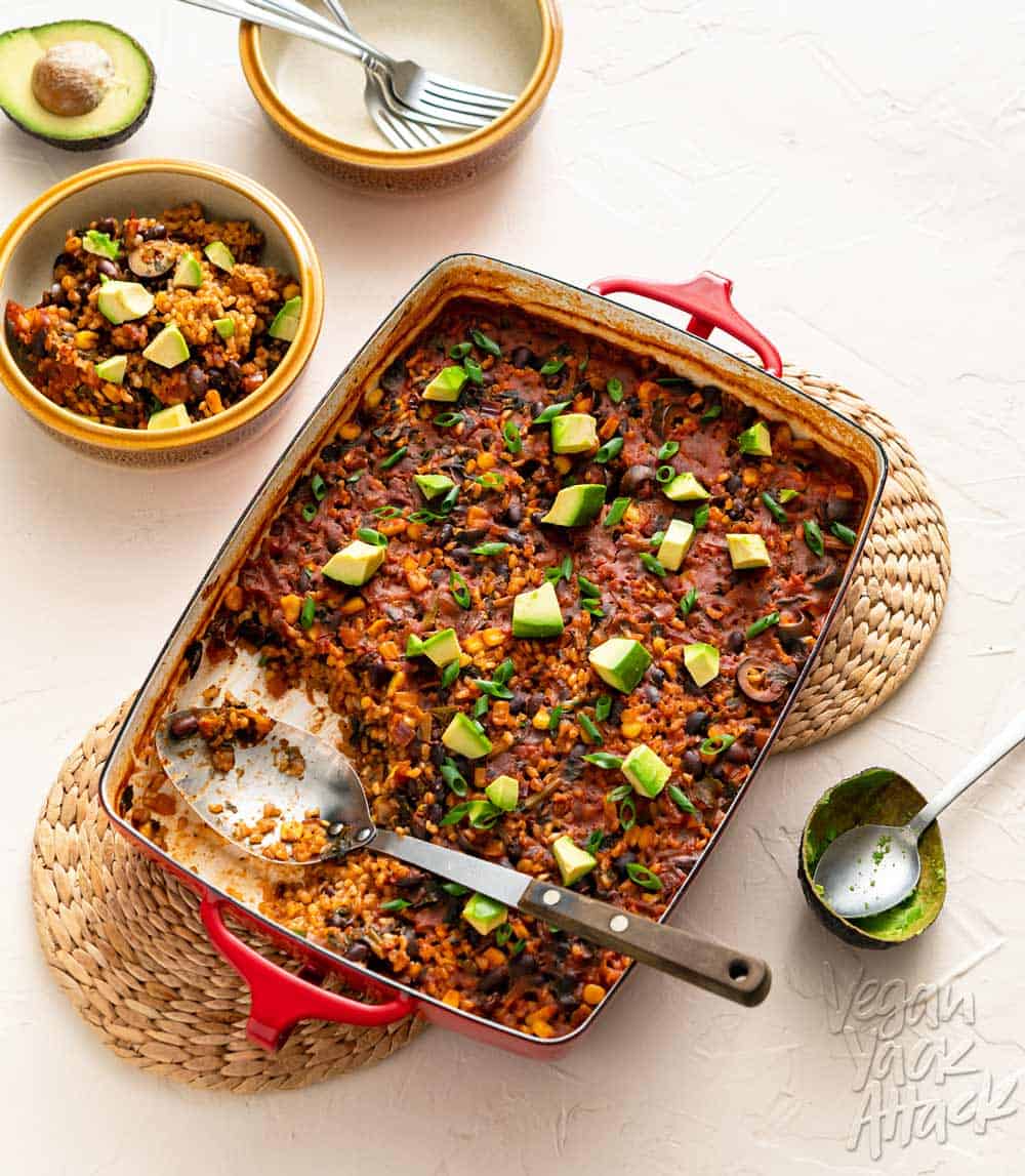 Image of chipotle brown rice bake in a red casserole dish on a beige background