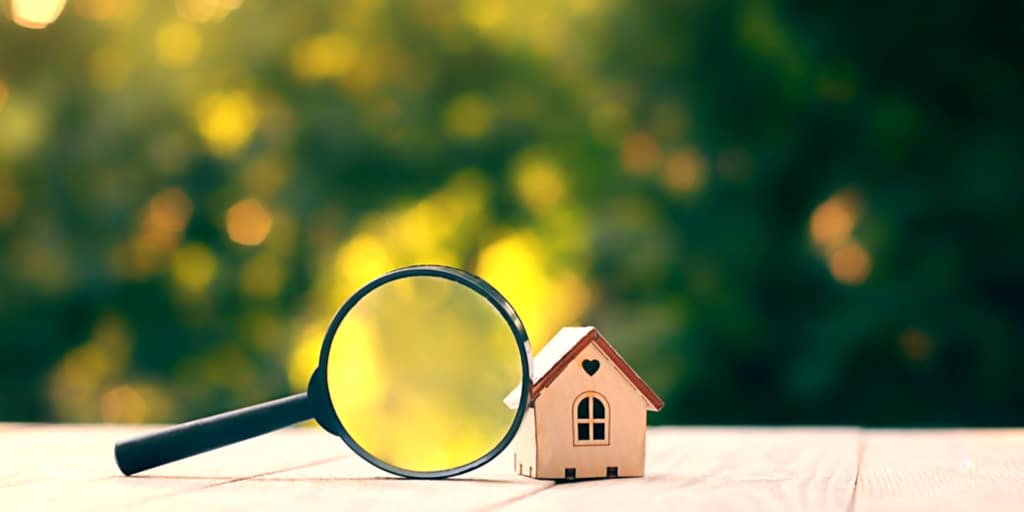 magnifying glass in front of small house