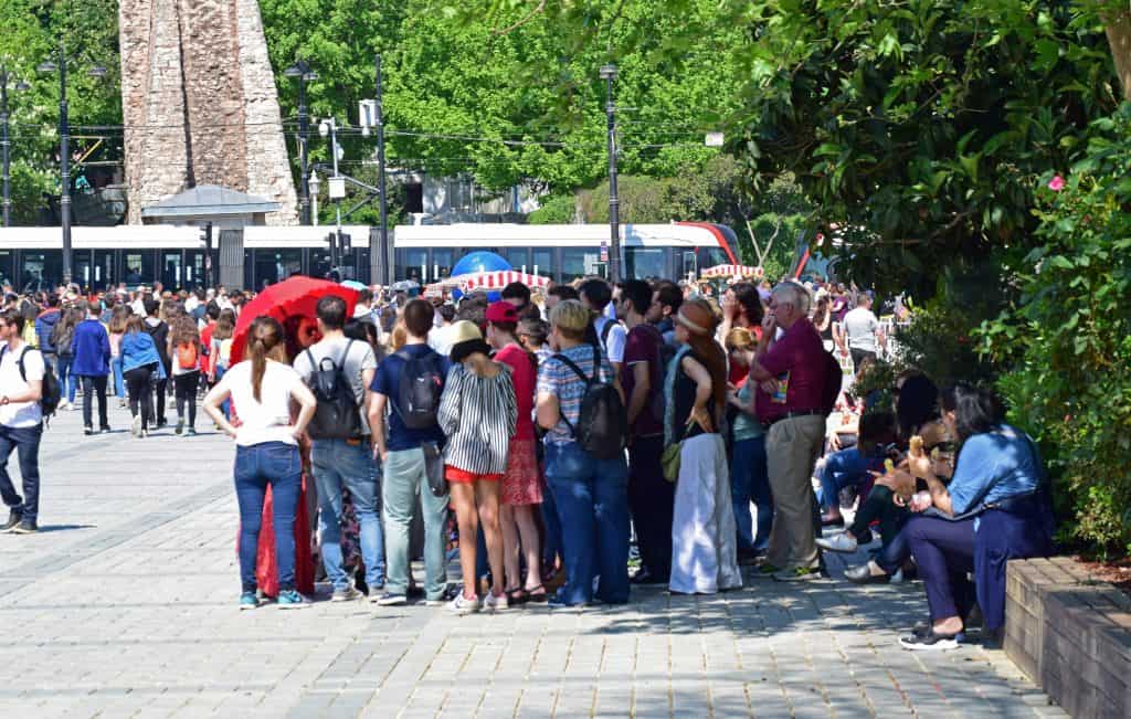 the girl with the red umbrella is leadig the free walking tour