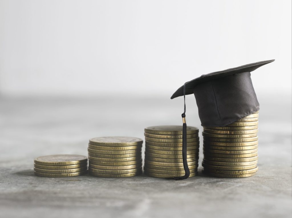 Stacks of coins with graduation cap.