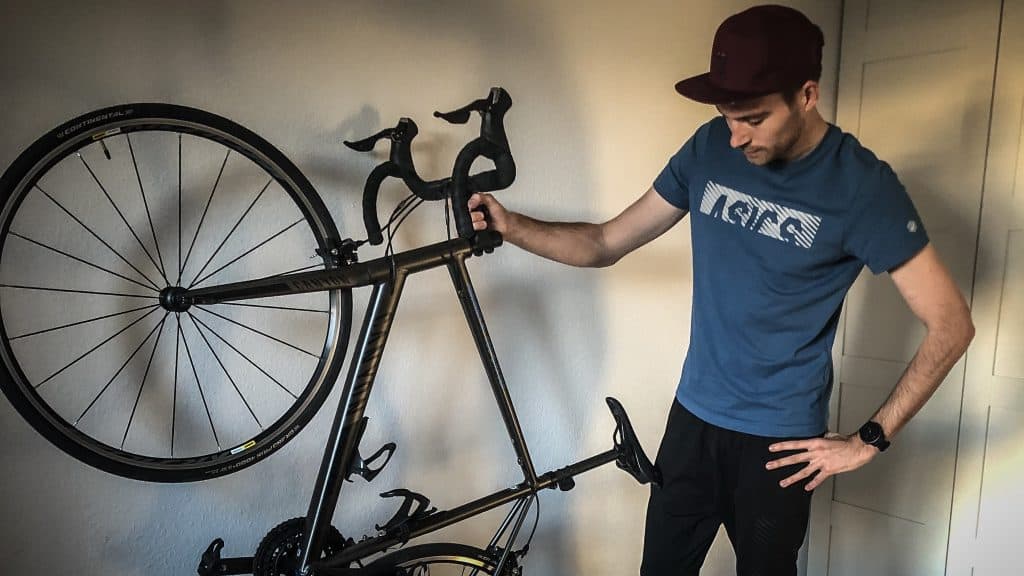 Sportler hält Fahrrad in der Hand