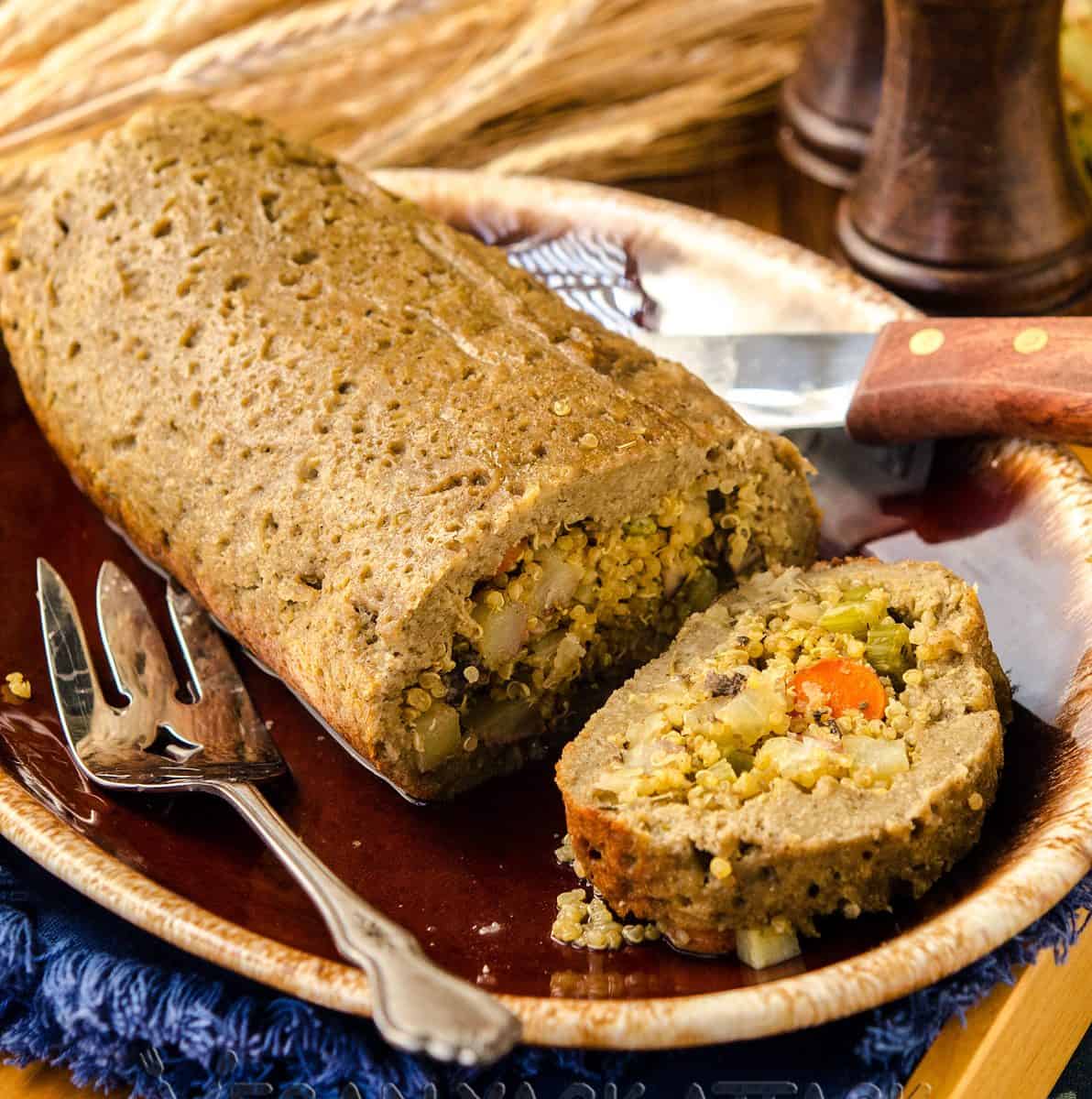 Stuffed Seitan Roast sliced on a ceramic plate with blue linen