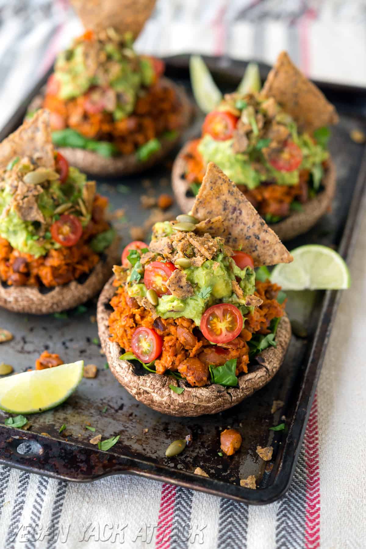 Image of stuffed mushrooms topped with guacamole and chips on a baking sheet, for the High-protein vegan meal prep menu