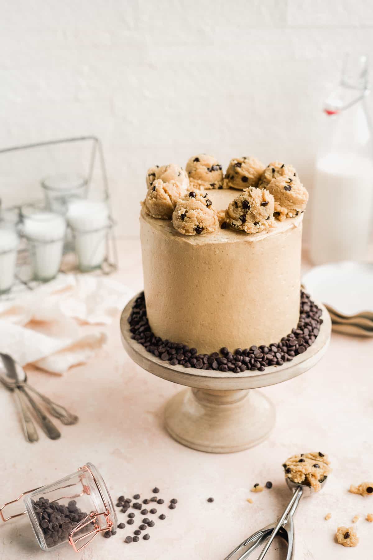 Cake with cookie dough on top on a pink surface.