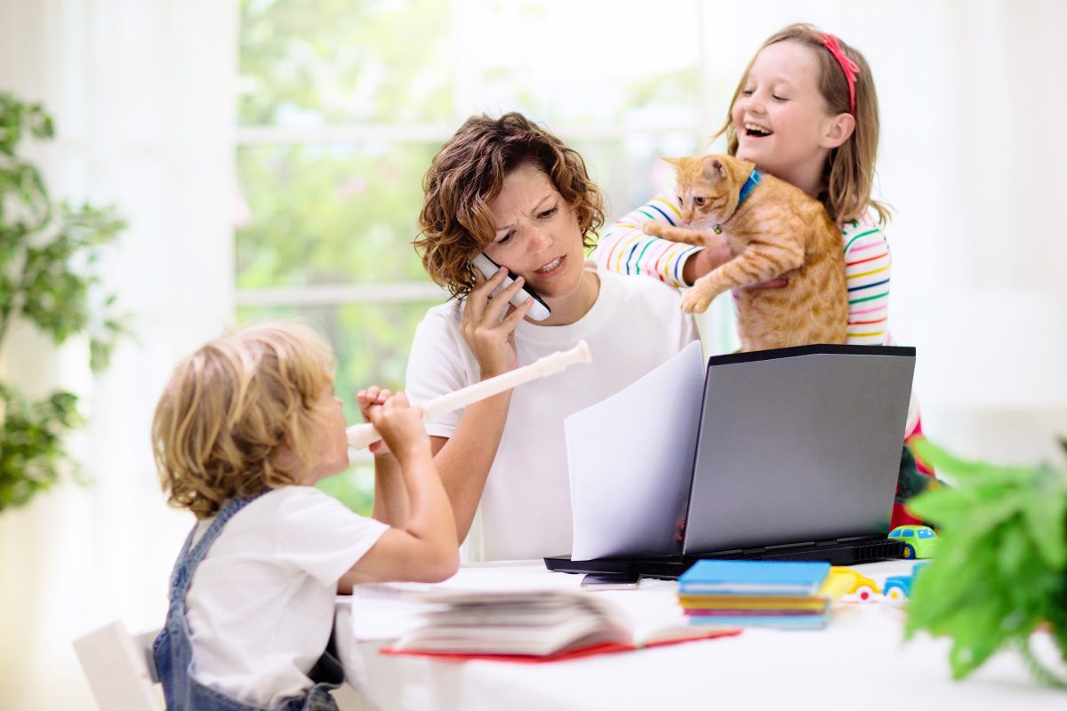 productivity tips- woman working from home with distractions of kids, pets, and noise