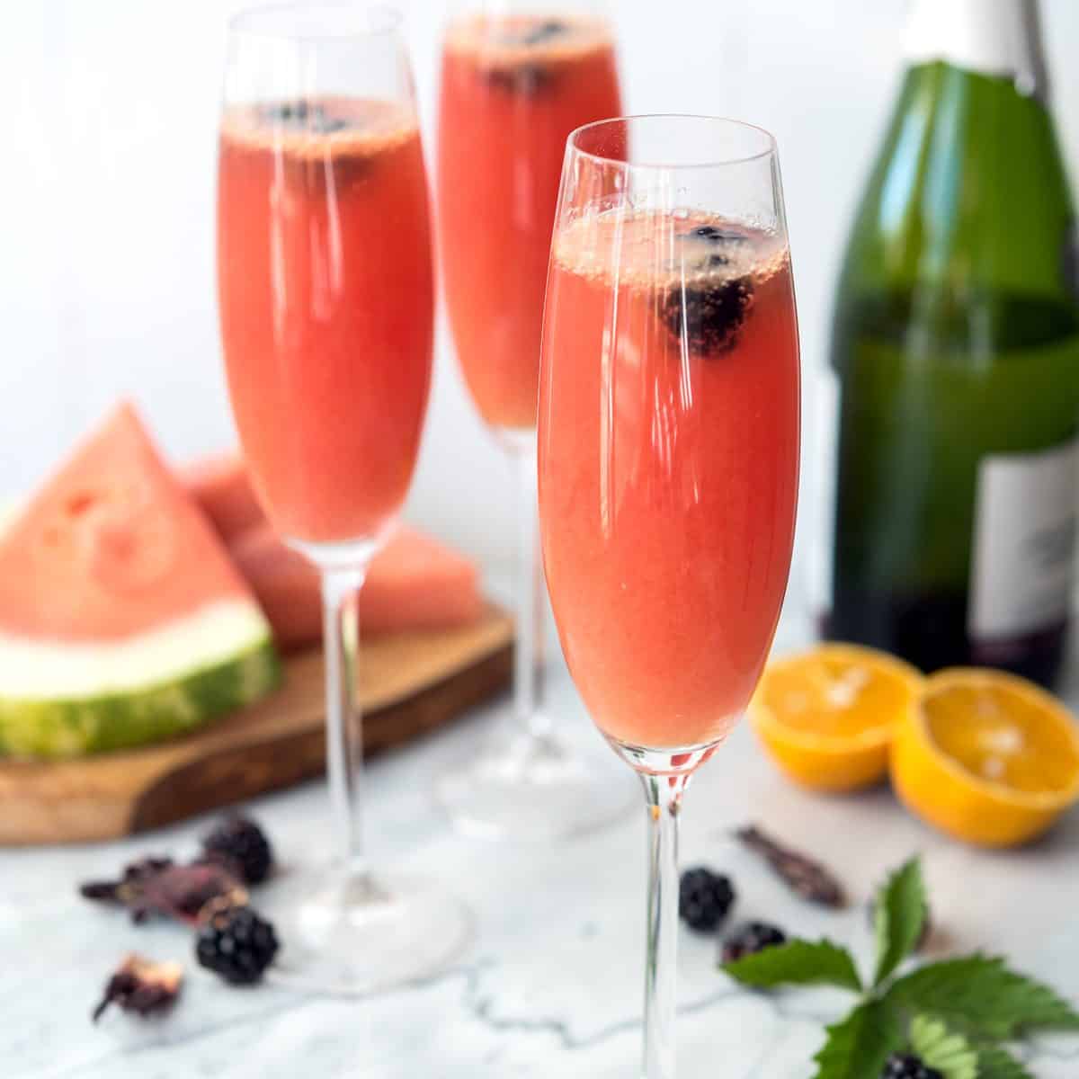 Refreshing watermelon, tart hibiscus tea, OJ and champagne make for the perfect, summer brunch beverage: Watermelon Hibiscus Mimosas! #vegan #allergenfriendly #brunch #drinks