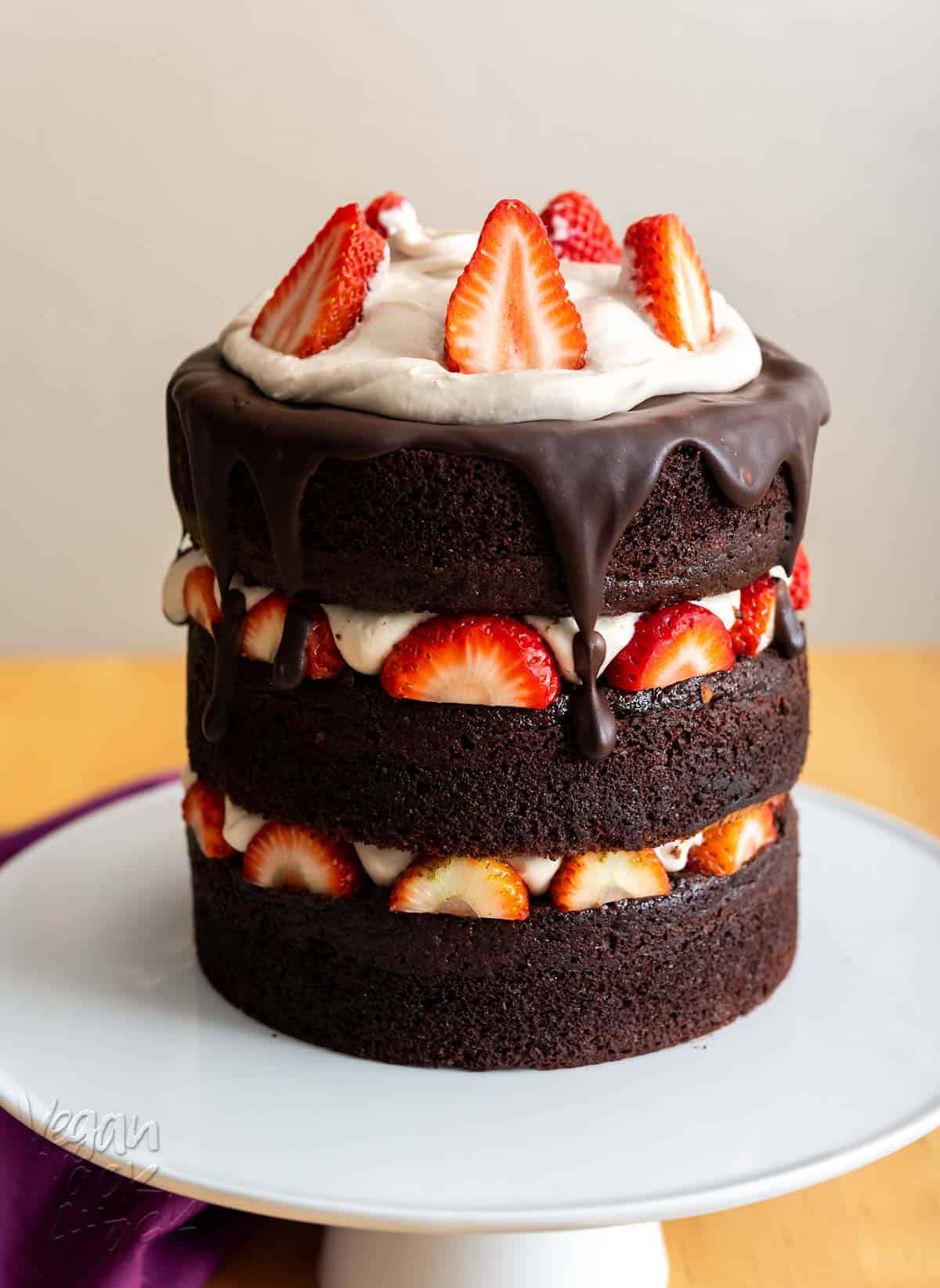 Image of chocolate layer cake with strawberries and vanilla mousse on a white cake stand