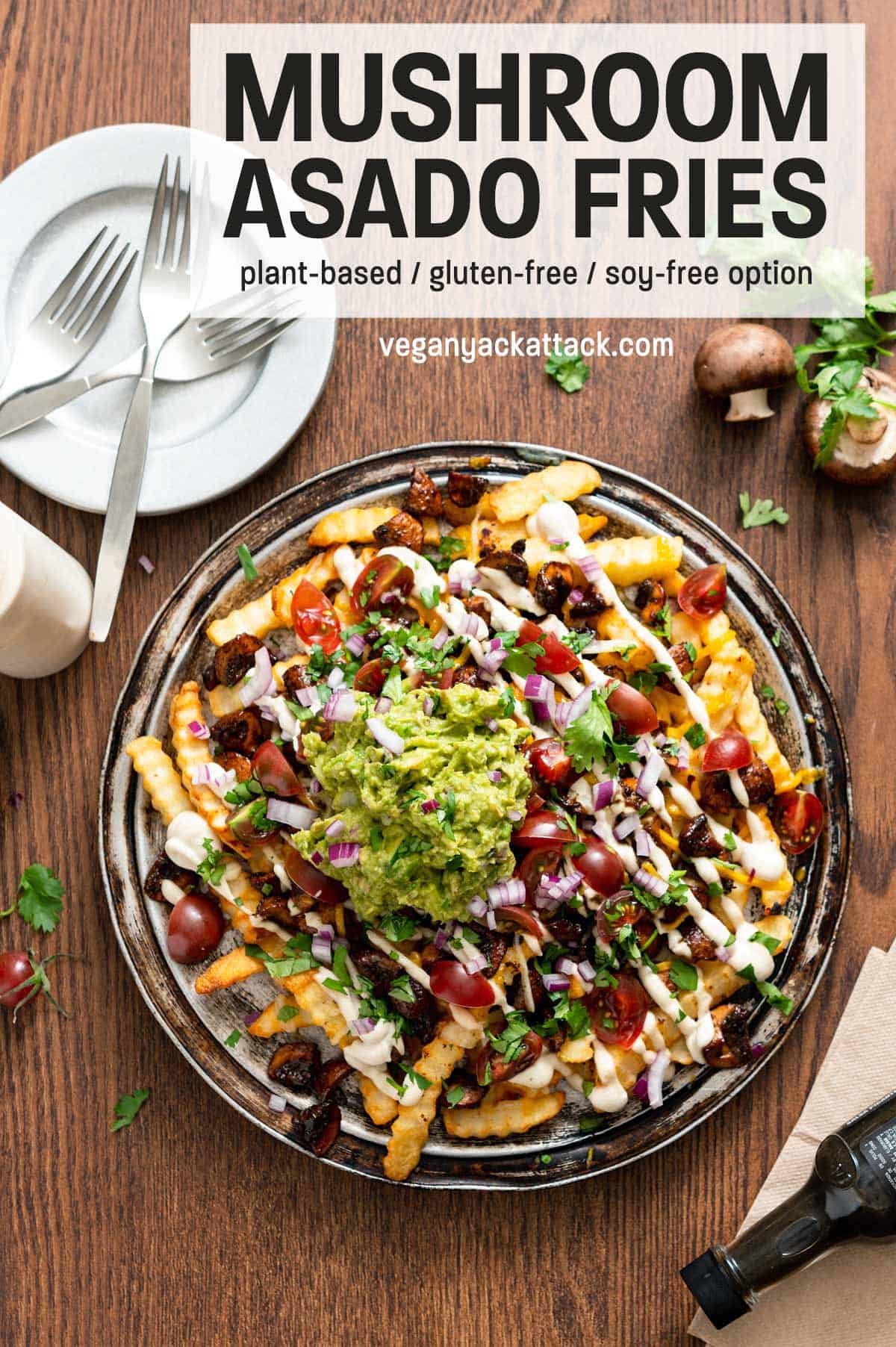Platter of vegan mushroom asado fries on a wood table, with plates and forks