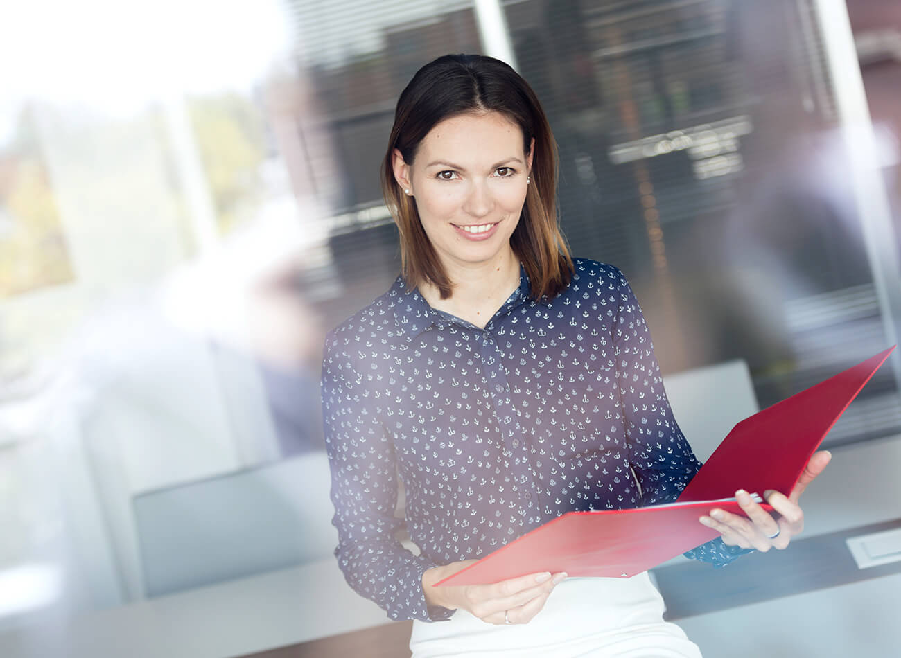 Office worker holding report and looking at camera