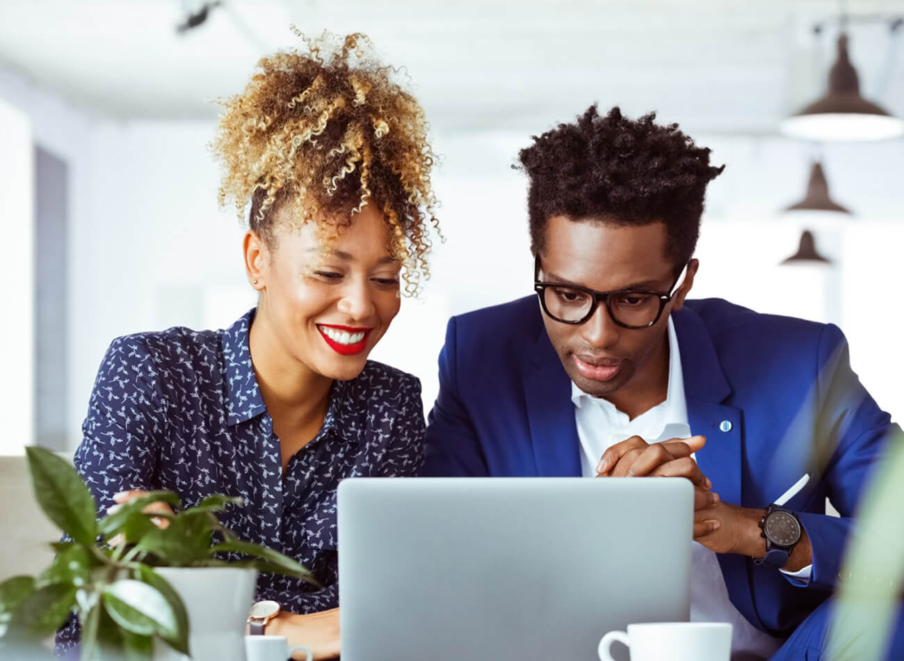 Female and male co-workers looking at laptop