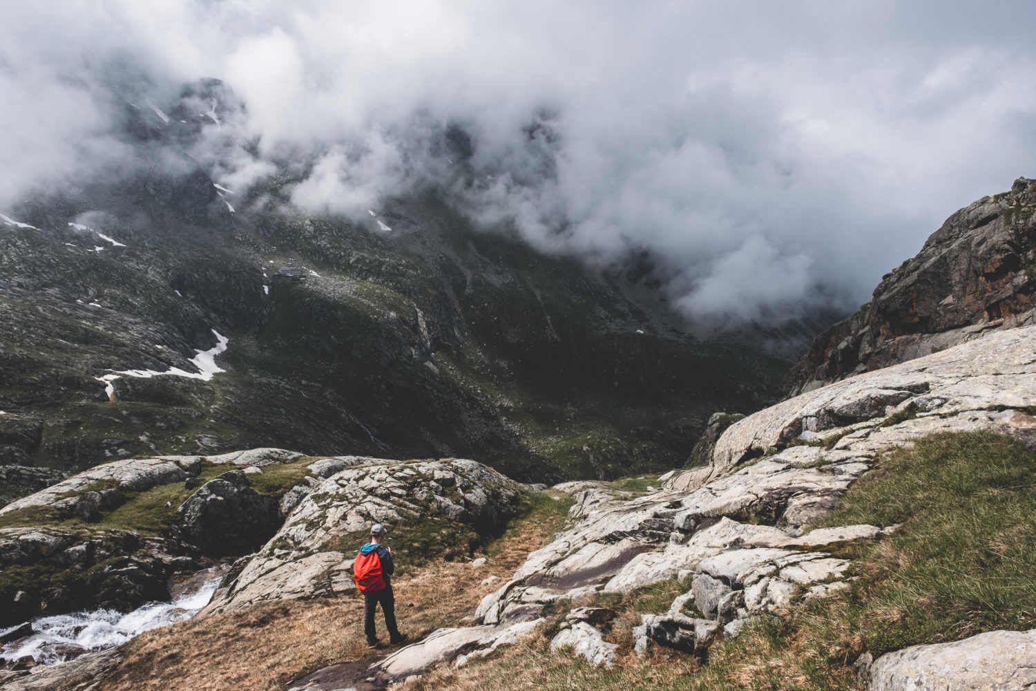 Wanderer auf dem Stubaier Höhenweg mit wolkenverhangenen Hänge