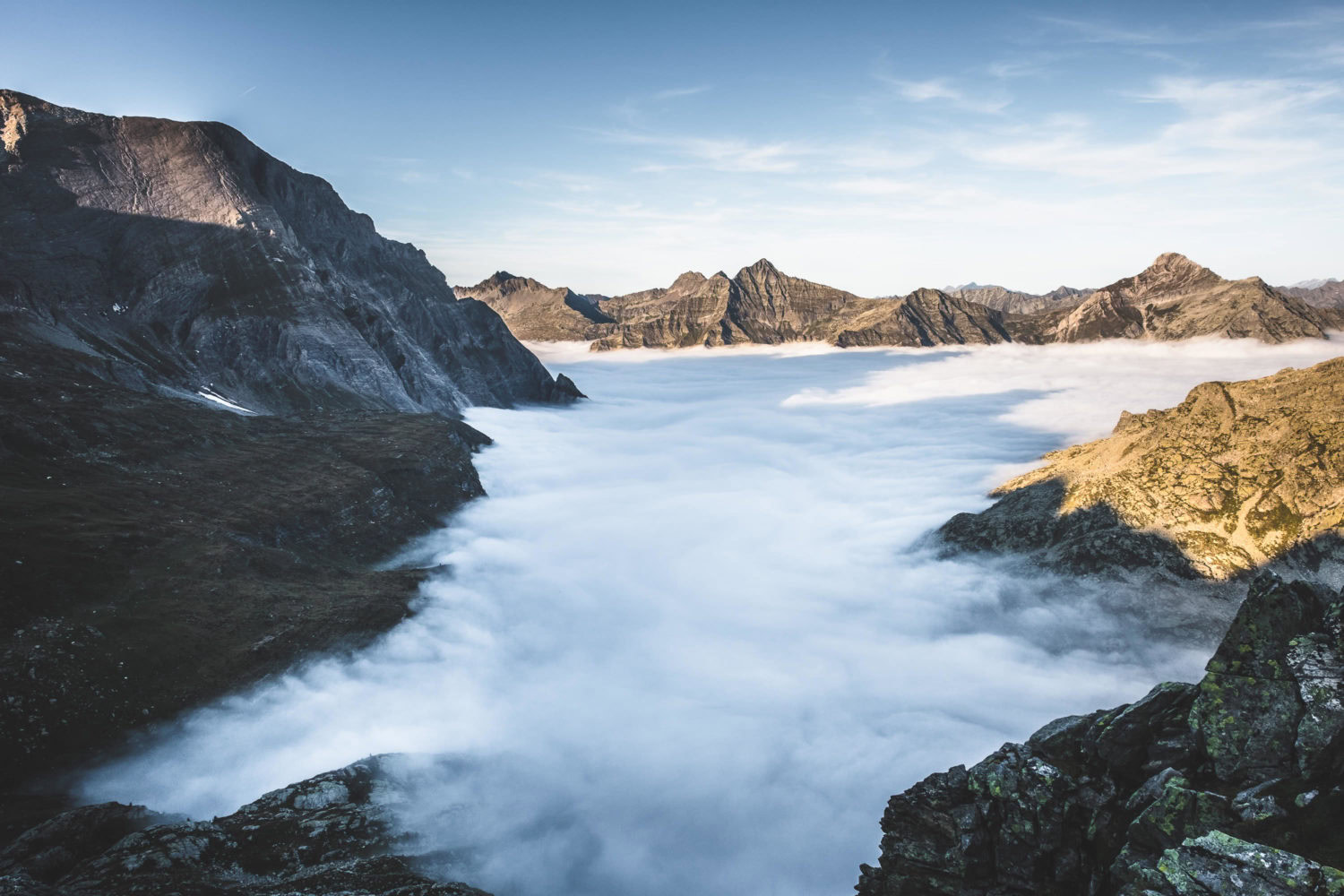 Wolken fließen zwischen Bergspitzen im Val Bavona