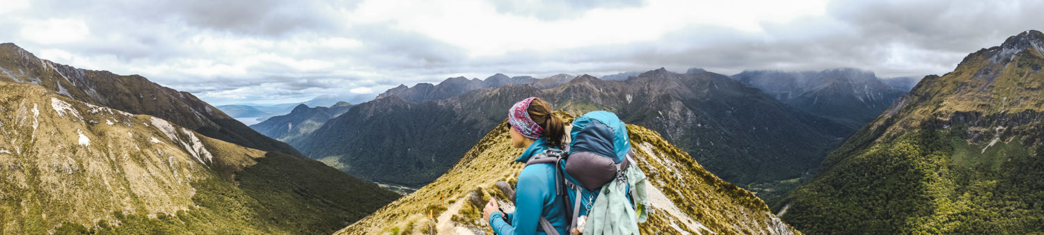Eine Frau mit Rucksack sieht in die Ferne