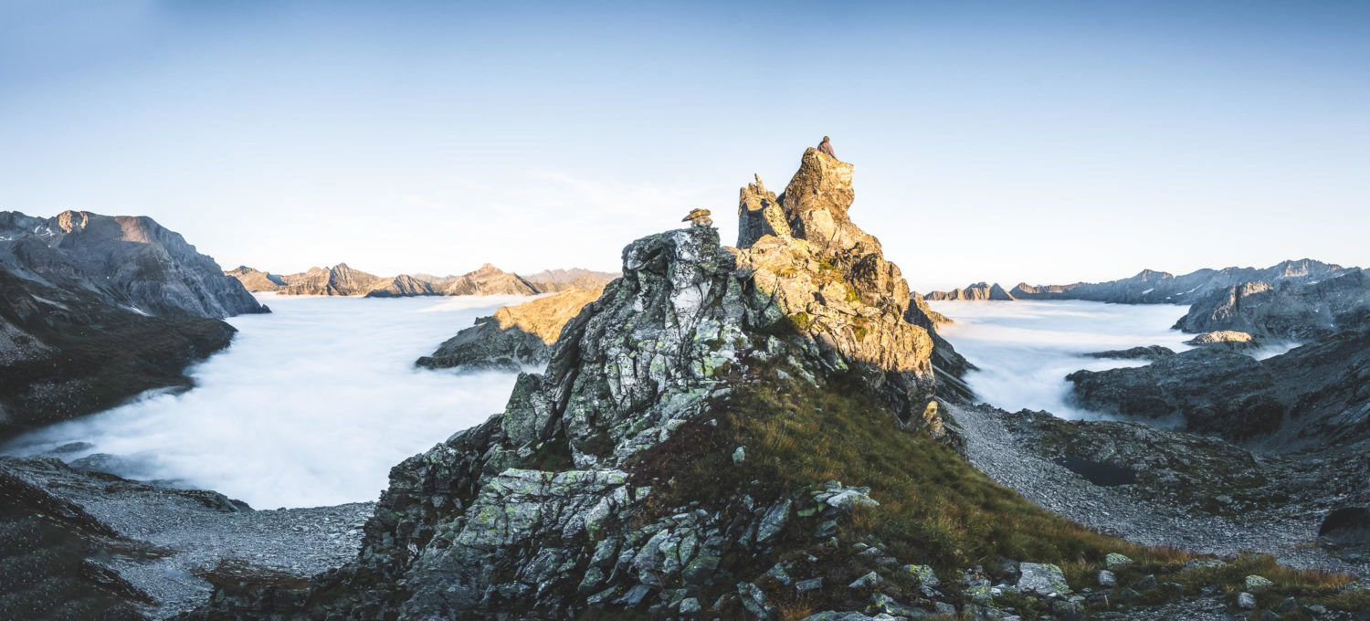 Panorama einer Berglandschaft mit Wolken zwischen den Bergspitze