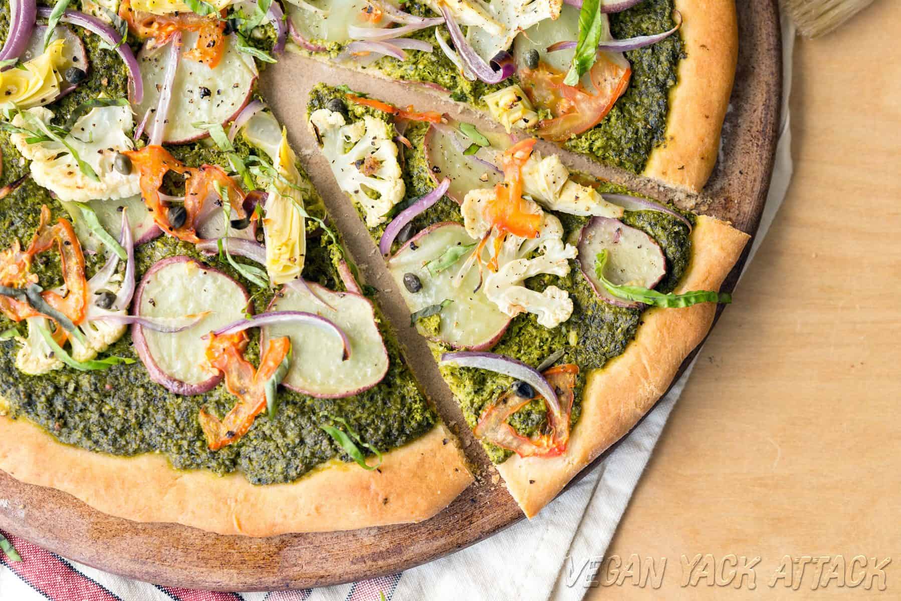 Close up shot of pesto potato pizza with slice cut out