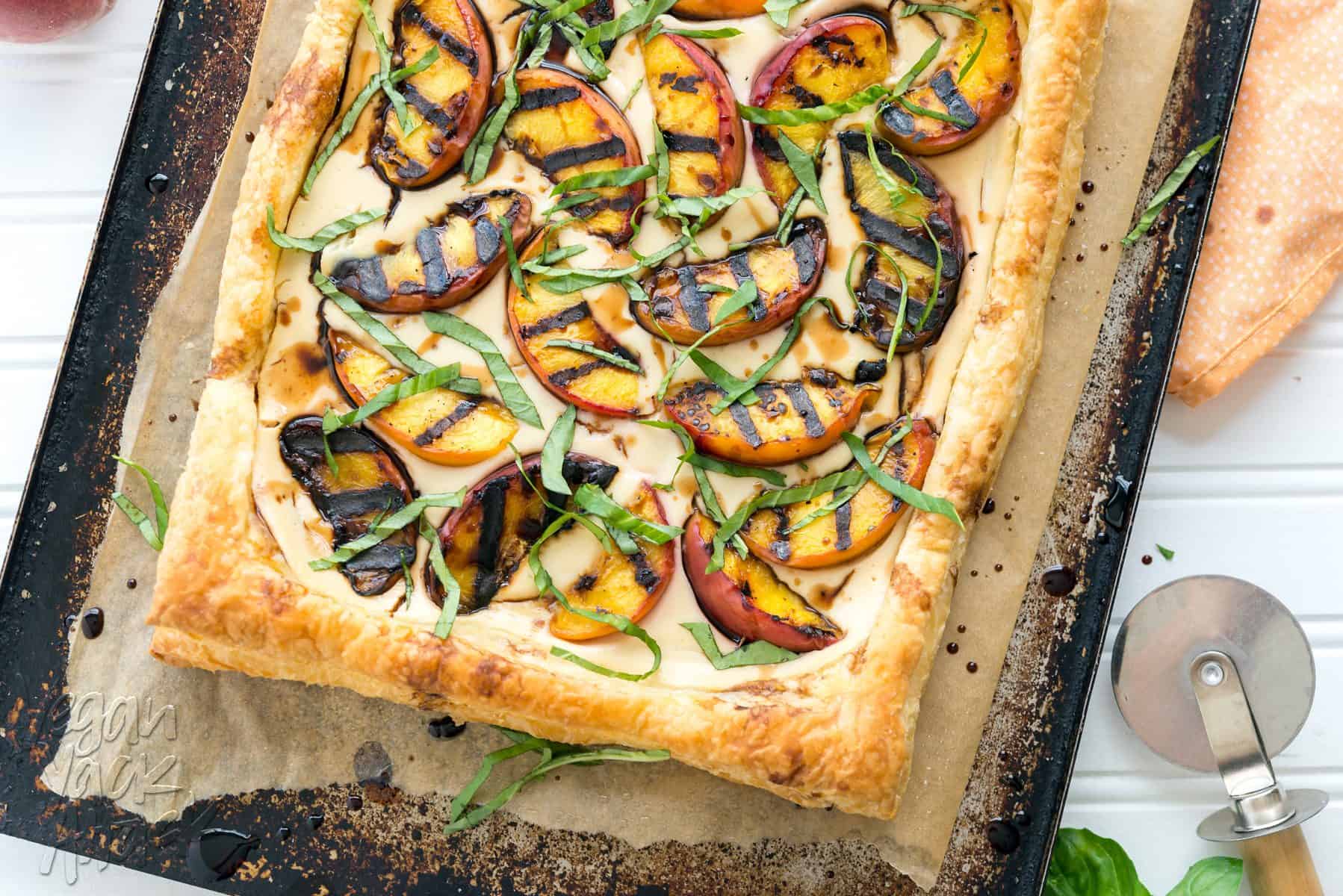 Grilled peaches and cream pastry on a baking sheet lined with parchment paper