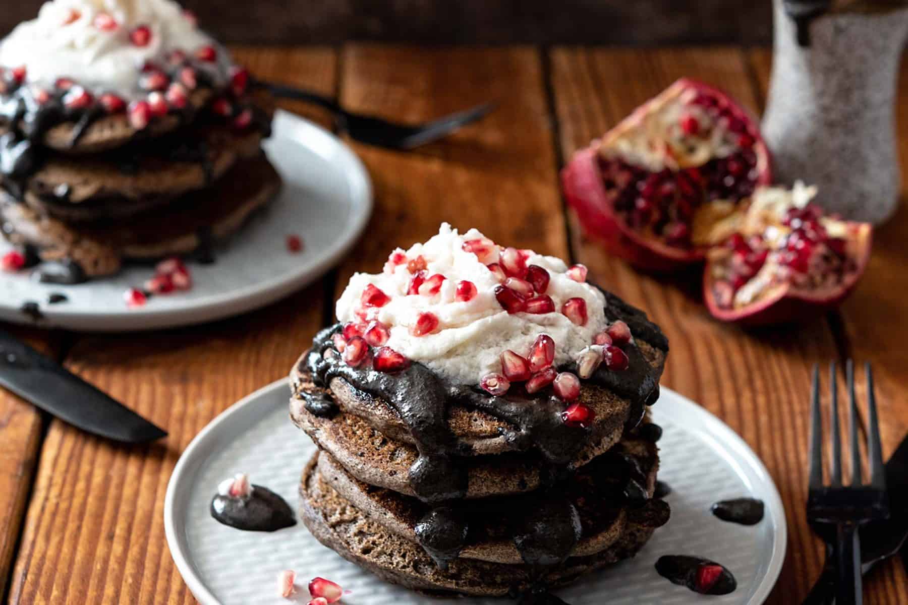 These Spooky Buckwheat Pancakes are eye-catching and delicious! Fluffy pancakes drizzled with a sweet black sesame sauce and topped with pomegranates, what more could you want? #Vegan #nutfree #glutenfreeoption #soyfree #halloween #veganrecipes