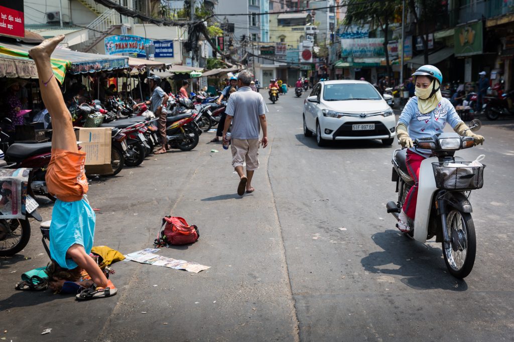 Street performer and motorcyclist for article on Ho Chi Minh City street photos