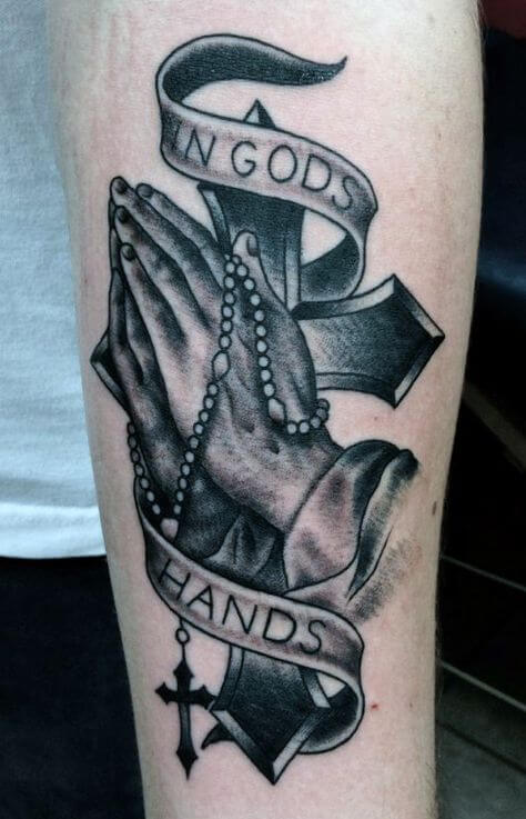 in gods hands banner tattoo with praying hands and rosary-cross