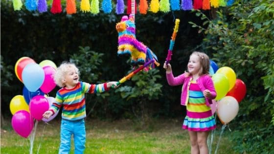 kids hitting pinata in backyard