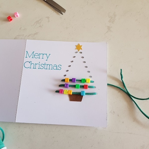 Threaded Christmas Tree card being threaded with the beads being added on each line of threading.