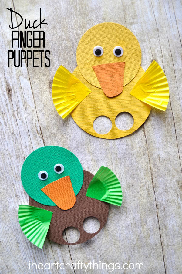 Vertical image of a yellow duck finger puppet and a mallard duck finger puppet laying on a faux wood background with the words "Duck Finger Puppets" in the top left corner.