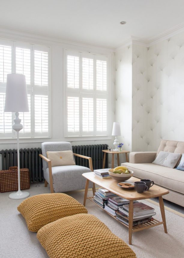 light grey living room with big knitted mustard floor cushions