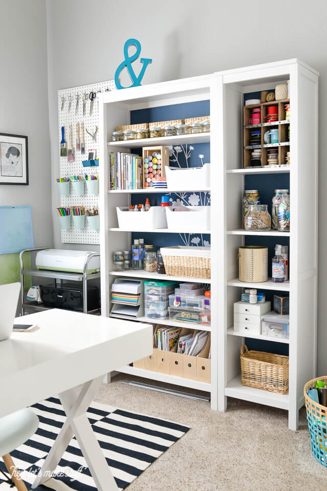 craft supplies organized on white bookcase
