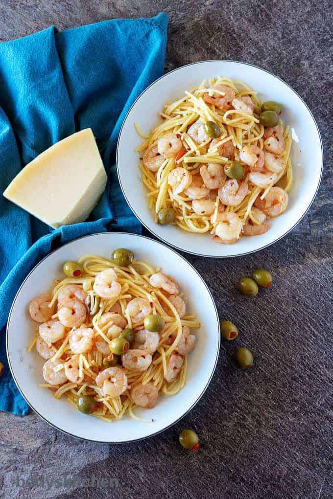 Ariel photo of the finished shrimp and pasta dishes with Parmesan cheese in white bowls.