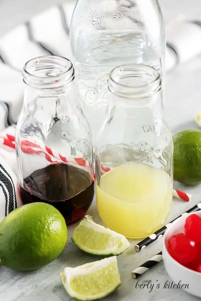 The cherry syrup and lime juice in small glass bottles.