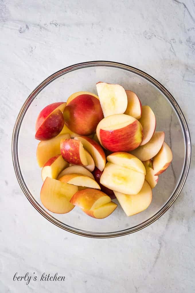 Two pounds of apples, in a bowl, cut into chunks..