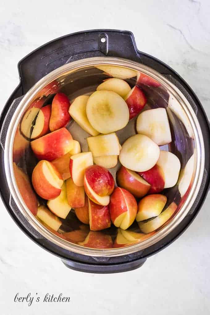 Apples have been tossed with lemon juice in the cooker.