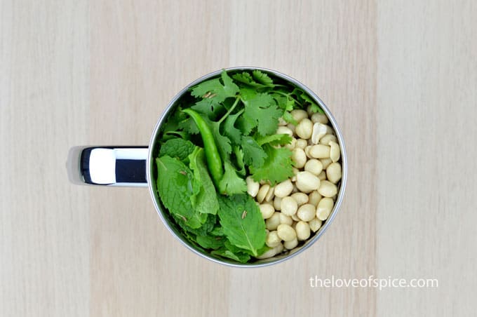 coriander and mint leaves, peanuts, green chilies, and cumin seeds in a mixer jar