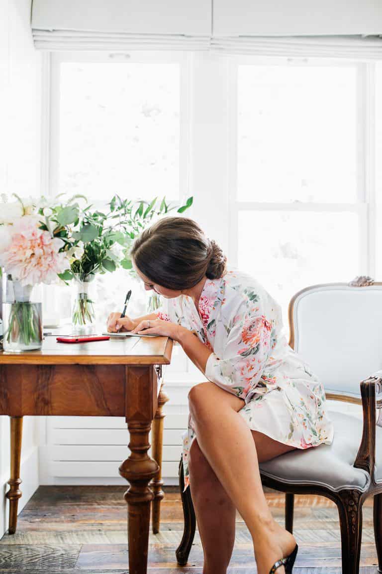 Bride writing down vows for wedding day morning
