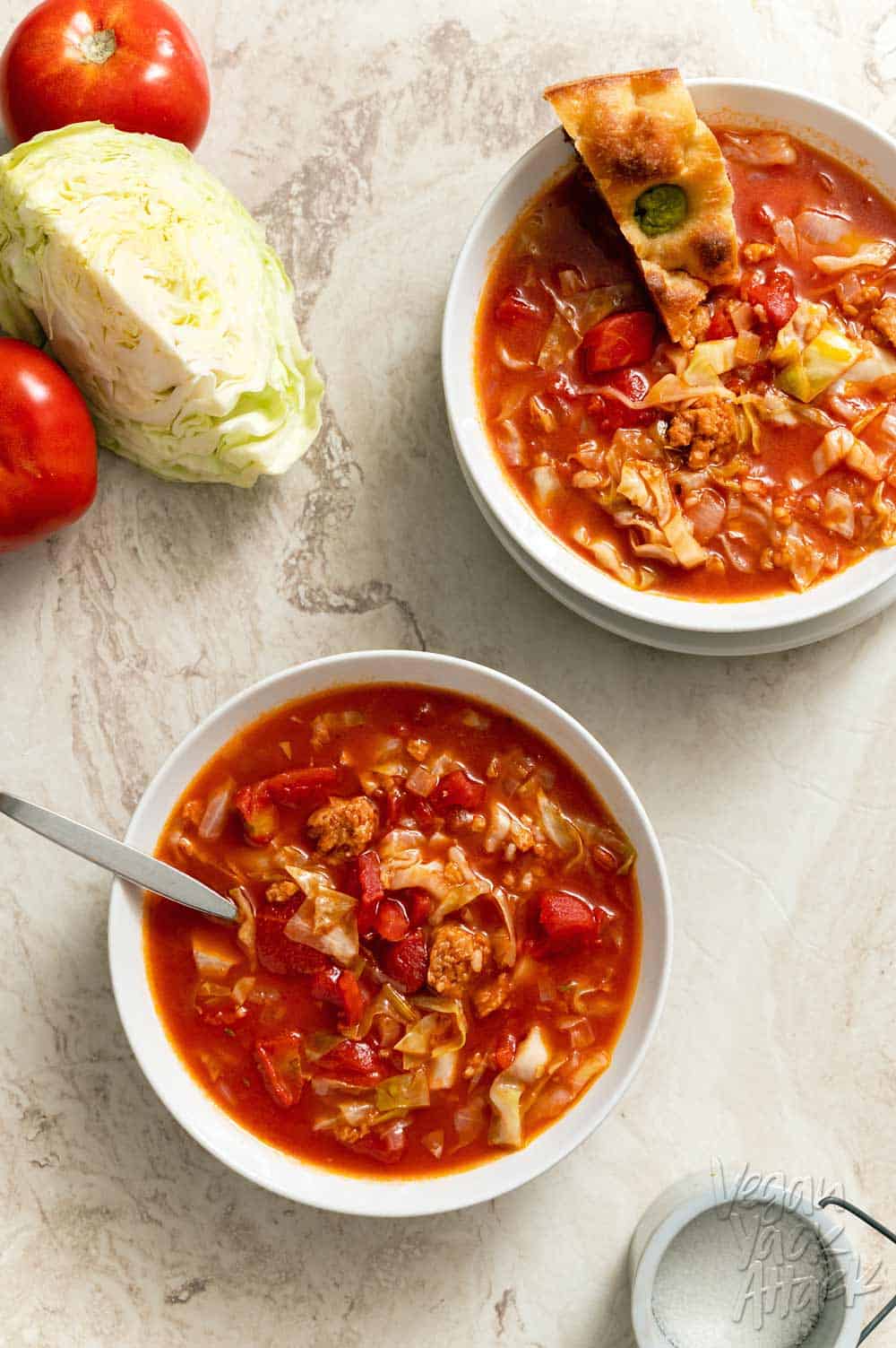 Two bowls of cabbage roll soup on a marble background