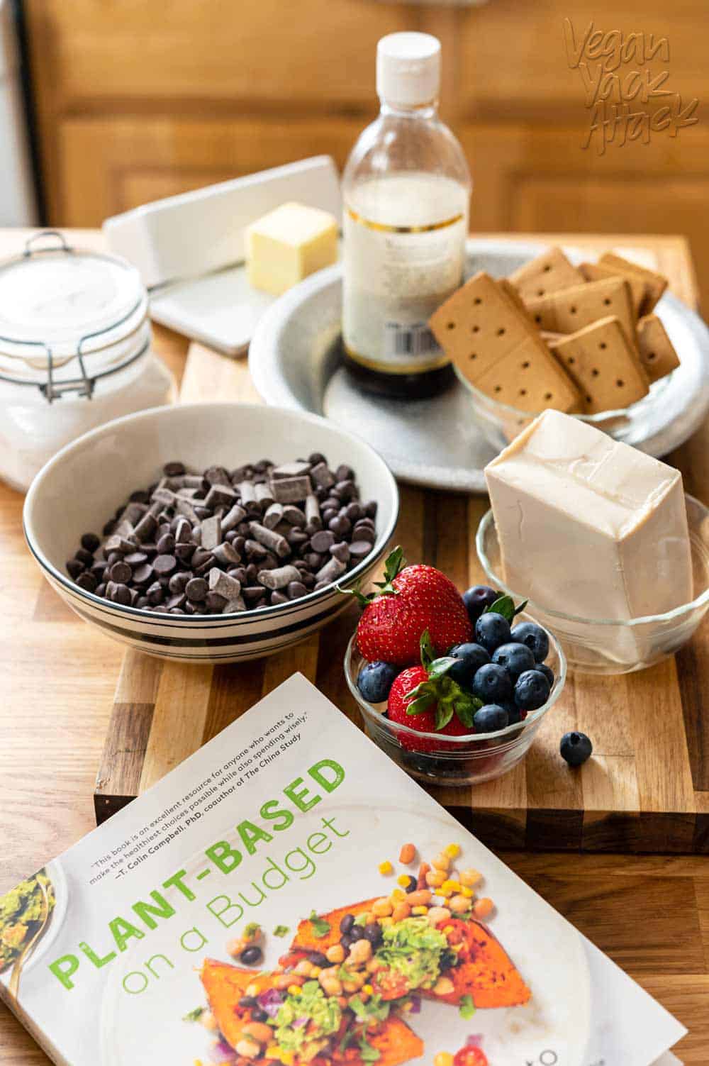 Ingredients for vegan dessert laid out on cutting board, plus the Plant-Based on a Budget cookbook