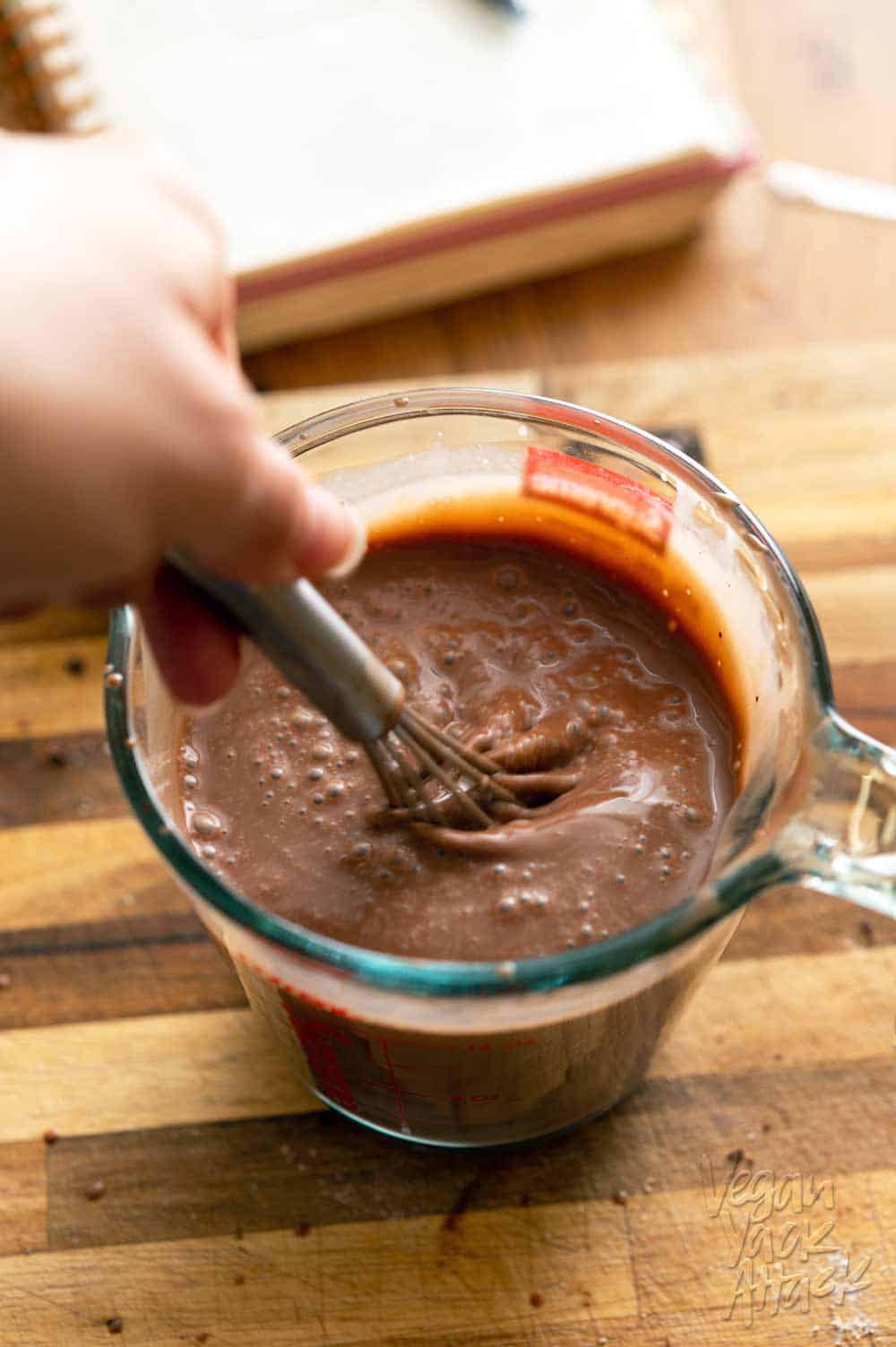 Whisking chocolate coconut milk mixture in a liquid measuring cup