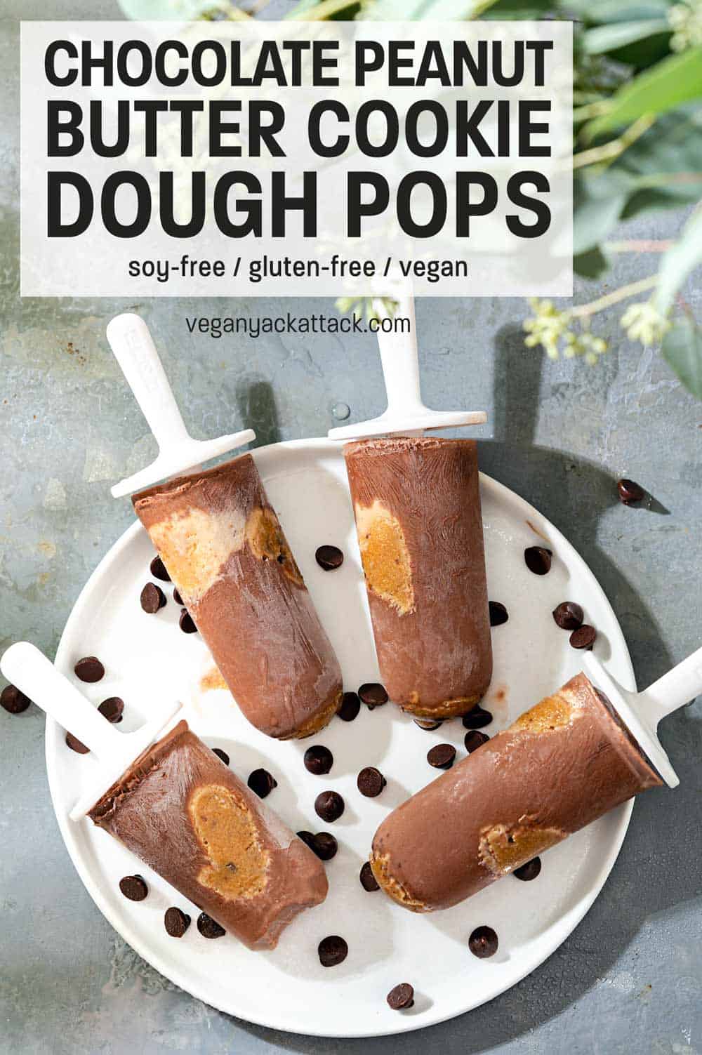 Four Chocolate Peanut Butter Cookie Dough Pops on a white plate with chocolate chips