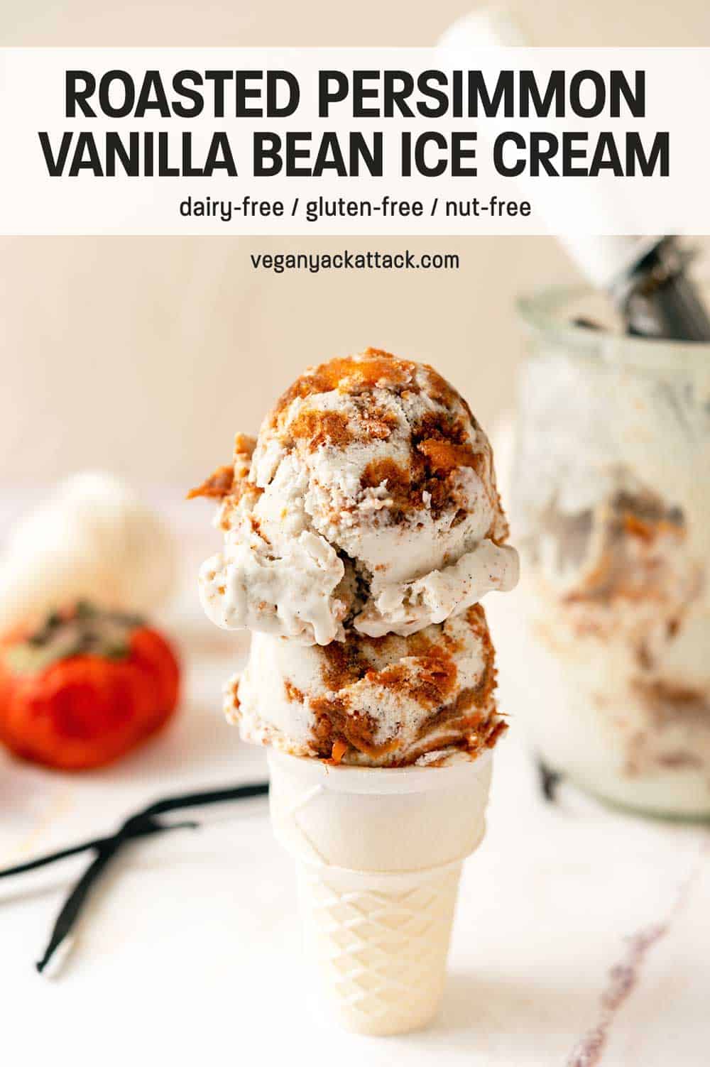 Two scoops of persimmon vanilla ice cream on a cone, next to a persimmon