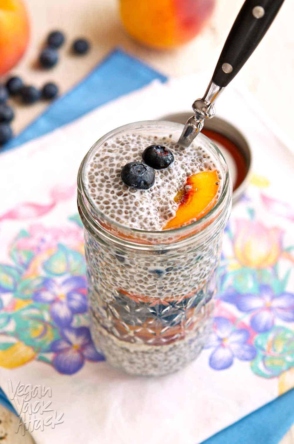 Blueberry Peach Chia Parfait - A pretty parfait with sensational vanilla chia pudding, the best peaches, and deeply colored blueberries. Gluten-free, Vegan Blueberry peach chia parfait in a glass jar on a floral linen