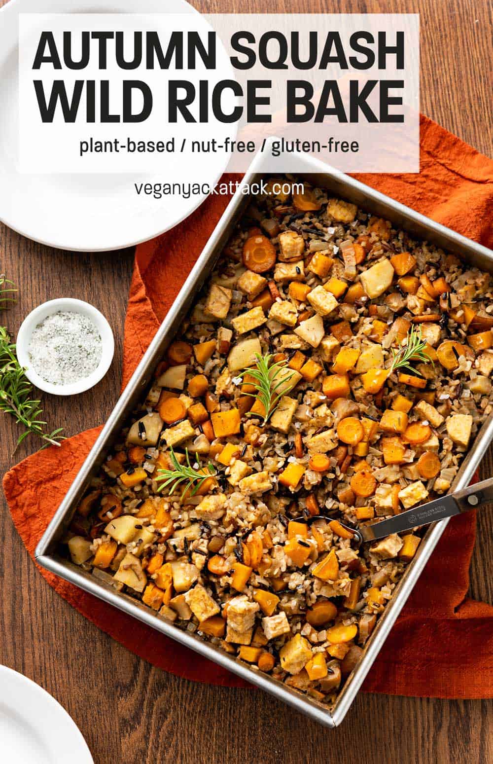 Large baking pan of squash wild rice bake on a brown wood table with rust-colored linen